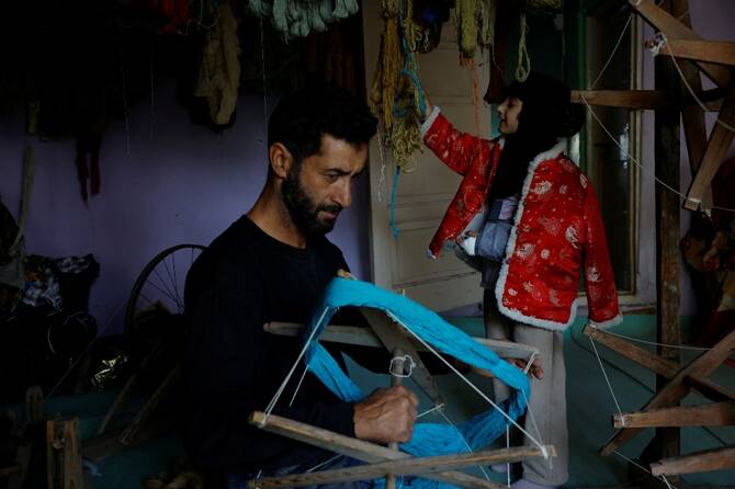 Gulzar Ahmad Bhat, 49, a carpet weaver, prepares and sorts thread on a traditional spinning wheel used to weave a Kashmiri carpet at his residence in Srinagar, Indian Kashmir. (Reuters)