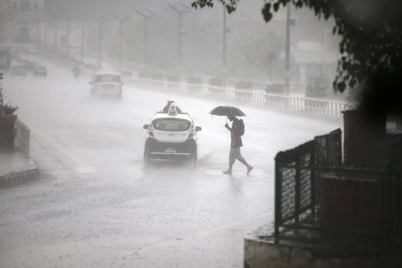 FILE PHOTO: A man holds an umbrella to shield the heavy rainfall as he crosses the road in Kathmandu, on Thursday, May 11, 2017. Photo: Skanda Gautam/ THT