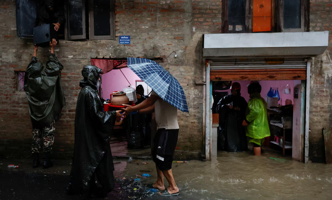 Members of Nepal Army help people retrieve their belongings to a safe area at a flooded street along the bank of overflowing Bagmati River following heavy rains, in Kathmandu, Nepal, October 4, 2025. REUTERS/Navesh Chitrakar