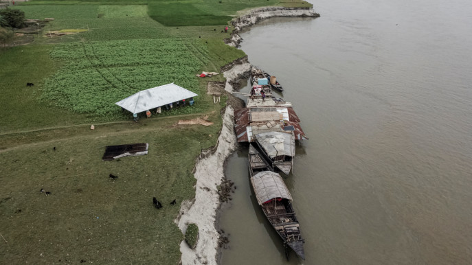A drone view shows people carrying the roof of the house belonging to Nurun Nabi, 30, who was forced to relocate to another island due to erosion caused by the Brahmaputra River, in Kurigram, Bangladesh on 29 October, 2025. Photo: Reuters