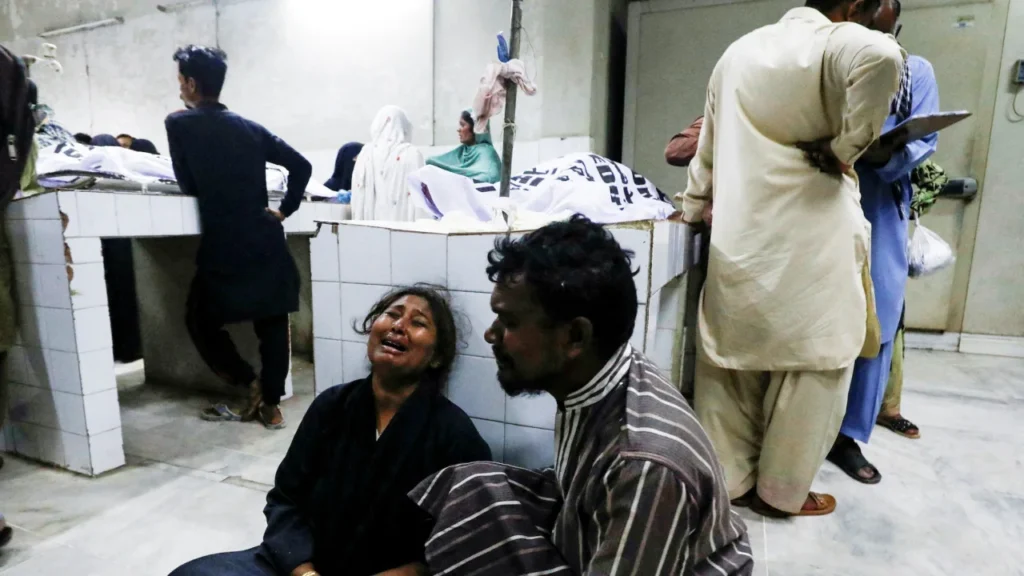 People mourn the death of a relative, who was killed along with others in a crush during a food distribution, at a hospital morgue in Karachi, Pakistan, on March 31