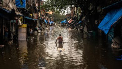 A man walks through a flooded street in the Scion neighborhood, along the Mithi River, of Mumbai, India, Aug. 4, 2019. (Bryan Denton/The New York Times)