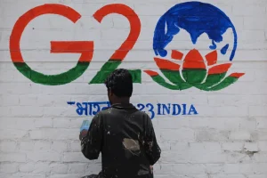 A man paints a wall with the G20 logo in the region's main city of Srinagar [Tauseef Mustafa/AFP]