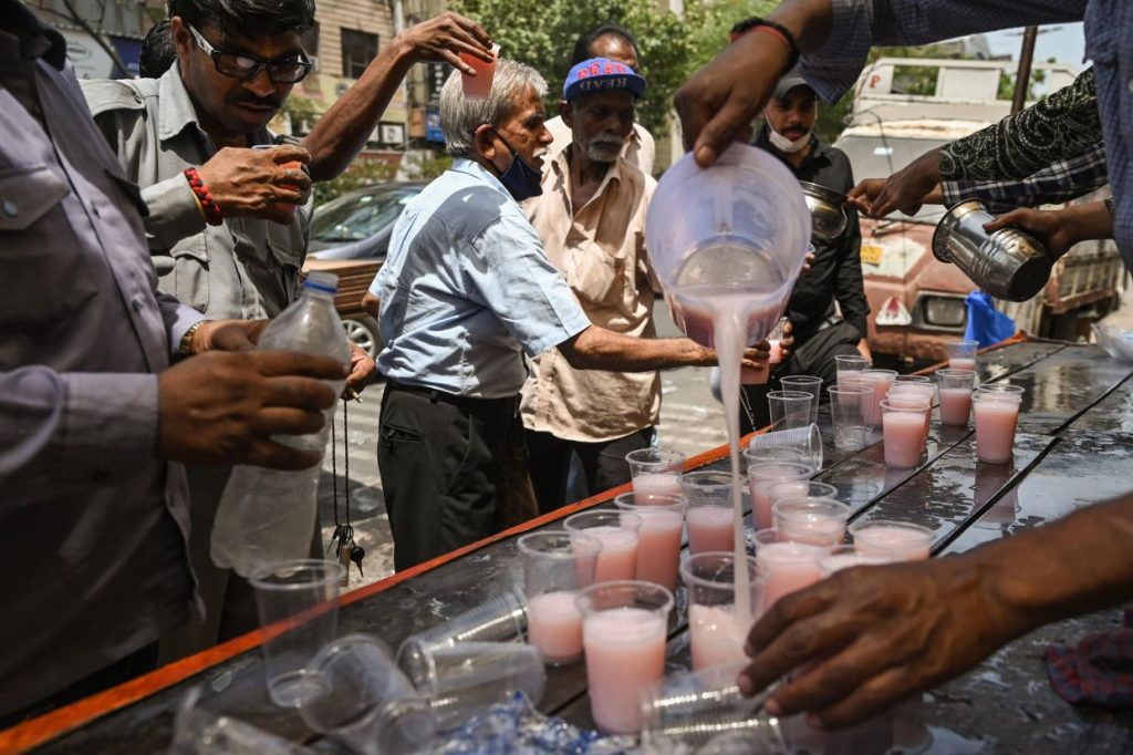 Volunteers distribute beverages to commuters as part of a free service on a hot summer afternoon in New Delhi on May 23, 2023. Scientists say global warming is exacerbating adverse weather, with many countries experiencing deadly heatwaves and temperatures hitting records across South-East and South Asia in recent weeks. - AFP