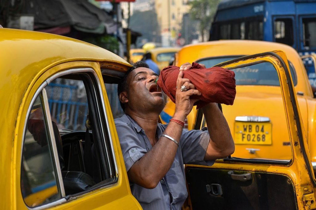 A taxi driver is seen drinking water from a bottle during afternoon heat in Kolkata, India, on April 18.