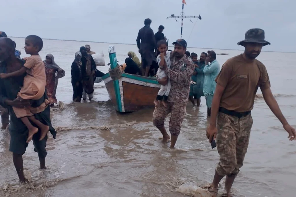 Soldiers help evacuate people from a village as Cyclone Biparjoy approaches, at a coastal area of Thatta district in Pakistan's Sindh province. [Handout: Pakistan's Sindh Rangers via AP]