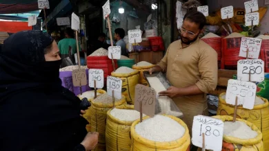 A shopkeeper fills a bag of rice for a customer, at a shop along a market in Karachi, Pakistan. -REUTERS PIC