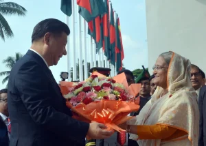 Bangladeshi Prime Minister Sheikh Hasina gives flowers to Chinese President Xi Jinping before their meeting at the Prime Minister's Office in Dhaka on October 14, 2016. China is an important geopolitical player in Bangladesh. Photo: Anadolu Agency / Stringer