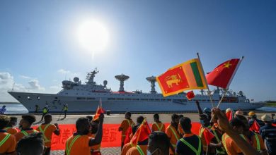 Workers wave China's and Sri Lanka's national flags upon the arrival of China's research and survey vessel, the Yuan Wang 5 at Hambantota port on Aug 16, 2022. (Photo: Reuters)