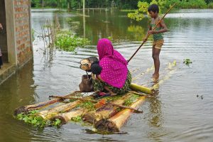 People travelling through flood waters by raft, June 26, 2022, in the Daudpur Union of Dakkin Surma Upazila of Sylhet.(MD RAFAYAT HAQUE KHAN/EYEPIX GROUP/FUTURE PUBLISHING/GETTY IMAGES)