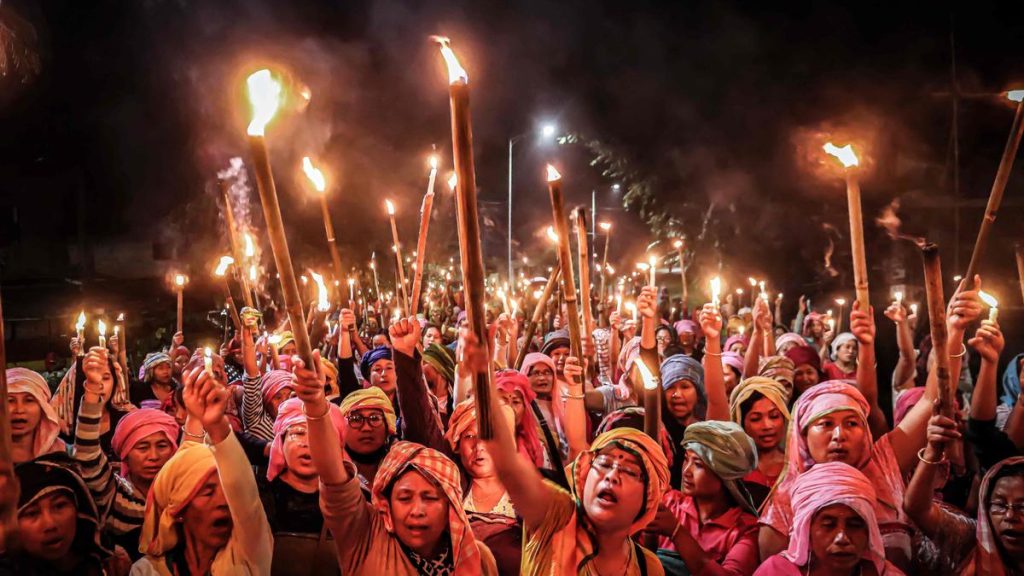In this picture taken on July 10, 2023, women belonging to the ‘Meira Paibis’, a group of women representing Meitei society, hold torches during a demonstation demanding for the restoration of peace in Manipur. | Photo Credit: AFP