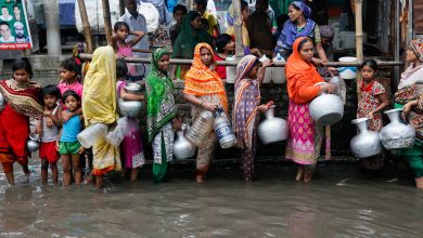 Women and children collect drinking water from a water logged area in Dhaka, Bangladesh. Credit: Mehedi Hasan/Alamy Stock Photo.