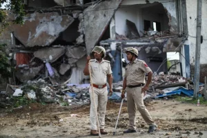 Police officers in front of the demolished house of a Muslim in Nallhar, Nuh [Md Meharban/Al Jazeera]