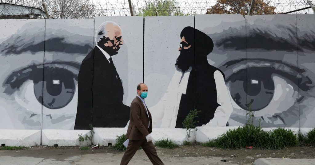 An Afghan man walks past a wall painted with a photo of U.S. Special Representative for Afghanistan Reconciliation Zalmay Khalilzad in Kabul, Afghanistan, on April 13, 2020. Mohammad Ismail/Reuters