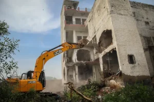 A bulldozer demolishes the property of a Muslim in Haryana's Nuh district [Md Meharban/Al Jazeera]