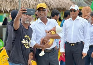 MDA leader Ahmed Siyam Mohamed standing by as President Solih takes a selfie with a supporter. (Photo/MDP)