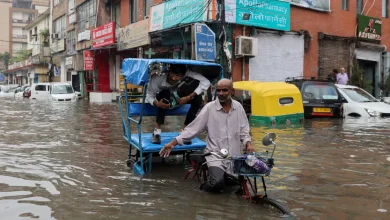 A man rides his cycle rickshaw with a passenger through a flooded street after heavy rains in New Delhi. [Anushree Fadnavis/Reuters] 9 Jul 2023