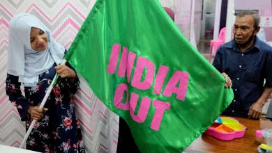 A worker with Mohamed Muizzu’s Progressive Party of Maldives poses with an “India Out” flag in Male last year. Photo: Reuters