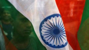 A boy's face is seen through the Indian national flag during Independence day celebrations in Mumbai, India, August 15, 2018/ Reuters