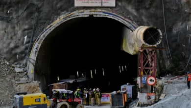 Rescue workers stand at the entrance of the tunnel in Uttarakhand [Shankar Prasad Nautiyal/Reuters]