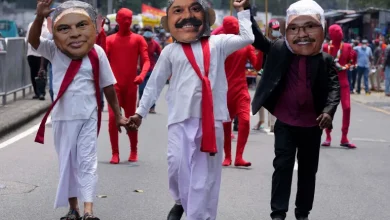 Sri Lankan protesters dressed as ex-President Gotabaya Rajapaksa, right, ex-finance minister Basil Rajapaksa, left, and ex-PM Mahinda Rajapaksa [File: Eranga Jayawardena/AP]