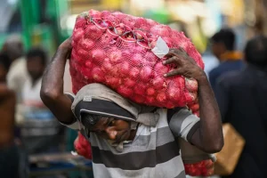 A labourer carries a sack of onions at a market in Colombo [File: Ishara S Kodikara/AFP]