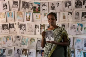 Thagbsiwaran Sivaganawathy holds a photo of her daughter, Thageswaran Susanya, at a protest for relatives of the disappeared on May 13, 2019 in Mullaitivu, Sri Lanka. © 2019 Allison Joyce/Getty Images