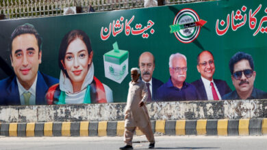 A man walks next to a billboard displaying photos of politician Bilawal Bhutto and his sister Asifa Bhutto, a day after general elections in Karachi, Pakistan February 9, 2024. REUTERS/Akhtar Soomro/File Photo