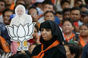 A woman holds a placard with photograph of Indian Prime Minister Narendra Modi during a public meeting in Ahmadabad [File: Ajit Solanki/AP]