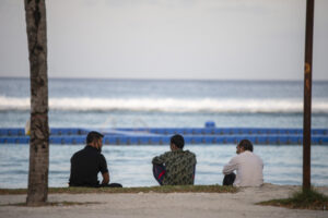 A group of migrant workers sit by the beach in Hulhumale'. (File Photo/Sun/Fayaz Moosa)