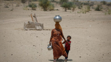 A woman walks back towards her home after filling water from a shallow well in a desert area on a hot summer day in Barmer, Rajasthan, India, April 26, 2024. REUTERS