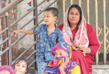 Tamanna Begum waits with her son Jisan on Dhaka’s Chief Metropolitan Magistrate court premises to see her husband, Ruel, who has been arrested for allegedly participating in the recent vandalism of the BTV centre. The photo was taken on Saturday. Photo: Mehedi Hasan