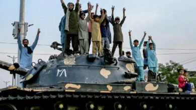 Pakistanis flashing victory signs stand over a tank in Multan as they celebrate after the ceasefire between Pakistan and India on May 10, 2025 [Shahid Saeed MIRZA / AFP]