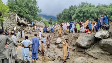 People gather at the site of a flash flood in Salarzai Tehsil in Pakistan's Bajaur district [AFP]