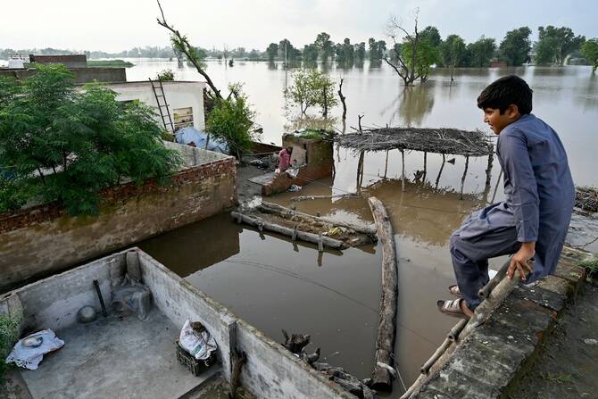 A flood-affected villager looks at the overflowing river Sutlej, as he sits over the rooftop of his house in Kasur district, Punjab province on September 3, 2025. (AFP)