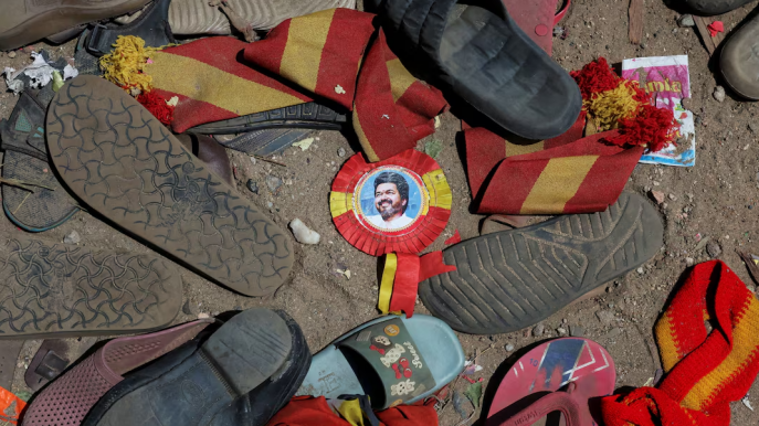A badge with picture of Vijay, actor and politician, lies amid footwears and other belongings left by attendees at the site of a stampede incident during an election campaign rally held by Tamilaga Vettri Kazhagam party, in Karur district of Tamil Nadu, India, September 28, 2025. Photo: REUTERS/Priyanshu Singh