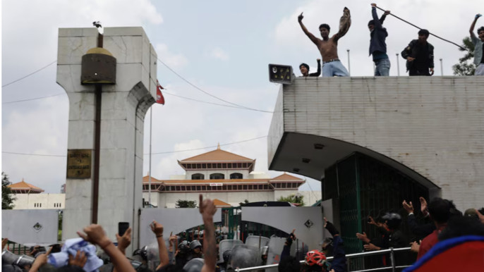 Demonstrators shout slogans as they stand atop the entrance of the Parliament during a protest against corruption and government’s decision to block several social media platforms, in Kathmandu, Nepal today, 8 September 2025. Photo: Reuters