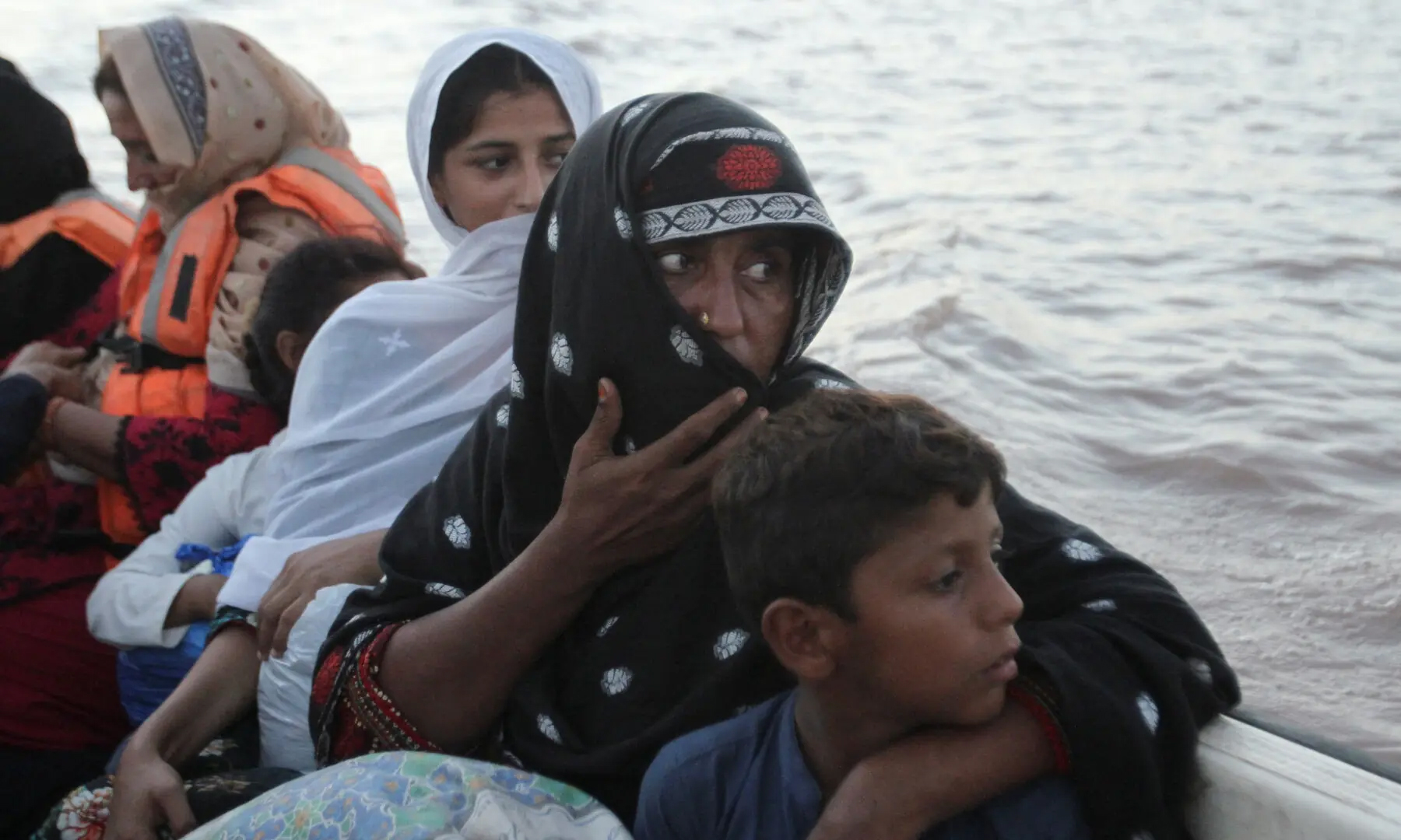 Tasneem Bibi sits with her children in a rescue boat as they evacuate following monsoon rains and rising water levels in the Chenab River, in Basti Khan Bela, on the outskirts of Jalalpur Pirwala, Multan, Sept 10. — Reuters