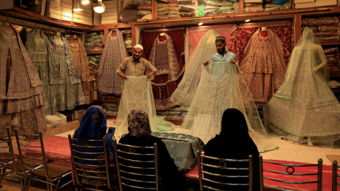 Shopkeepers display bridal dresses to customers at a shop in a cloth market in Karachi, Pakistan September 23, 2025. Photo: REUTERS/Akhtar Soomro/File Photo